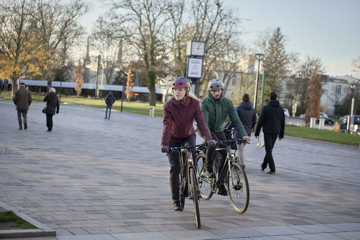 Radfahrerin mit Regenjacke bei nassem Wetter