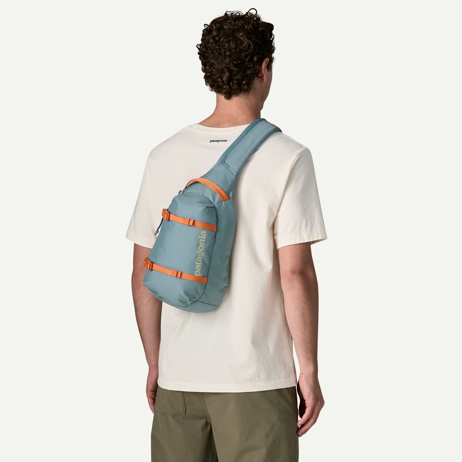 Patagonia Atom Sling 8L in Blue Sage über der Schulter getragen – Rückansicht