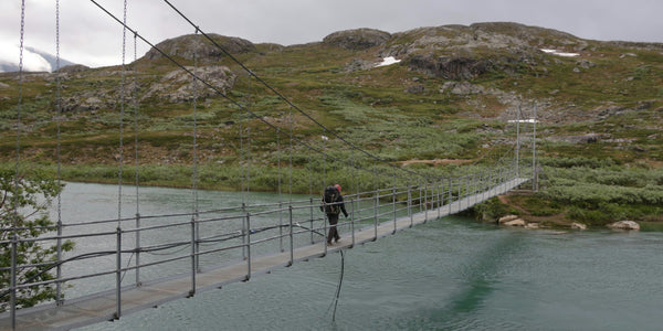 Wanderer überqueren die Hängebrücke bei Alesjaure am Kungsleden in Schwedisch-Lappland