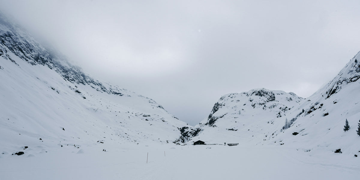 Person auf Ski in einem ruhigen, verschneiten Hochtal in den österreichischen Alpen