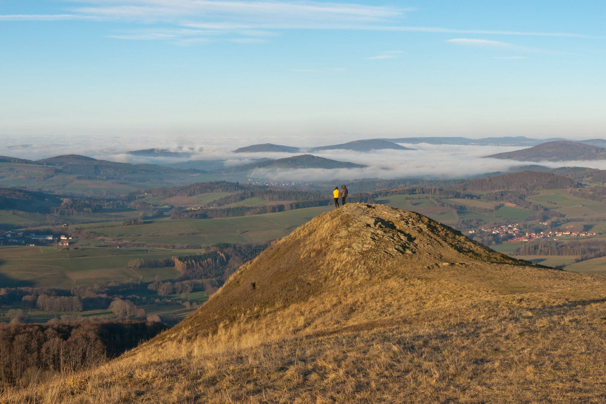 Zwei Wanderer auf der Abtsrodaer Kuppe in der Rhön im Herbst, Blick über Nebel und Kuppen